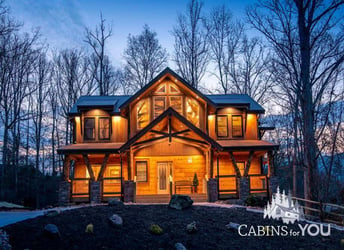 Log cabin in woods at nighttime