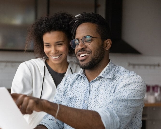 Man and woman looking at a direct mail postcard.