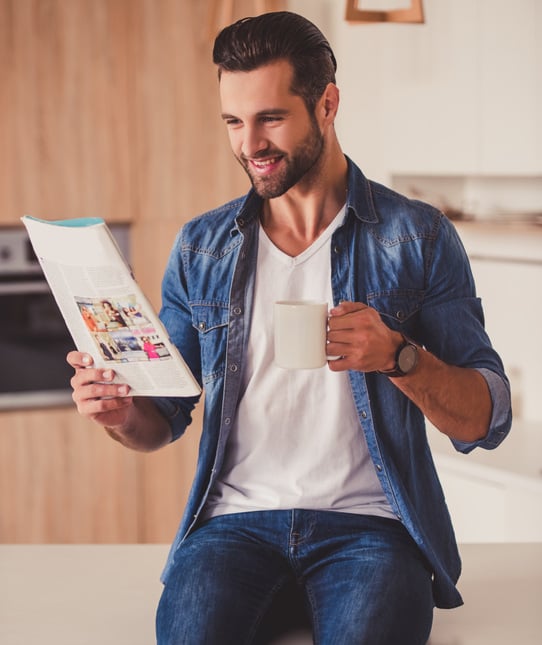 Man looking at a catalog in the kitchen.