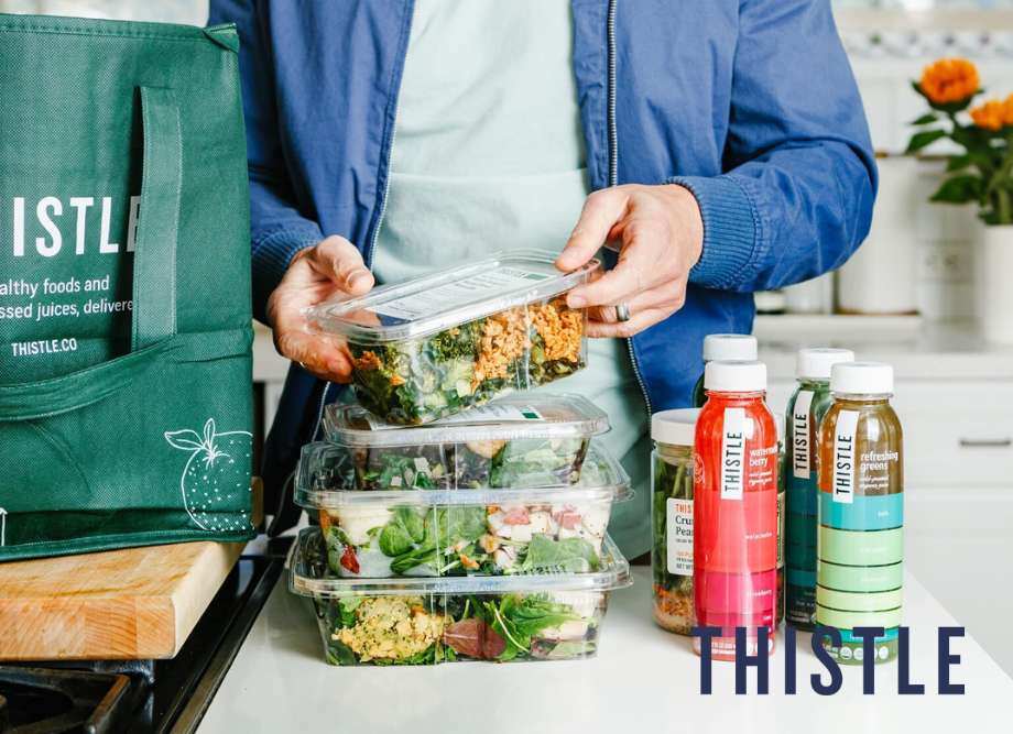 Person standing in kitchen with pre-prepped meals and drinks