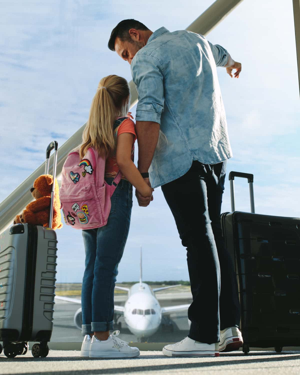 Man and daughter waiting for airplane to arrive. 